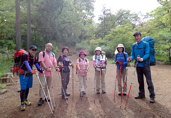 「高尾山ブランチ」を主宰する土方善明さん（写真右）。2本のストックを使って歩行する「ノルディックウォーキング」のスタイルで登ります。