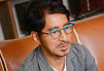岡田さんの仕事用メガネのひとつ。メガネだけを見ると派手に思えるが、実際にかけてみると、想像以上に顔に馴染み、明るい印象を演出してくれる。