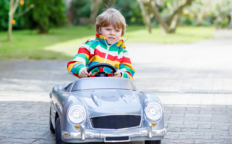 クラシックカーのおもちゃに乗る少年