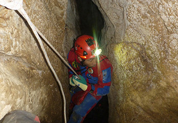 三重県の洞窟「霧穴」探索の様子。洞窟内では、岩の間をロープをつたって降りていくことも…。